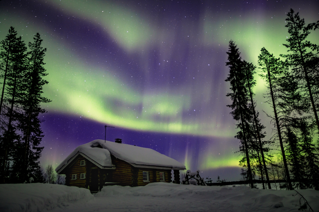 Northern Lights in the night sky over winter Lapland landscape