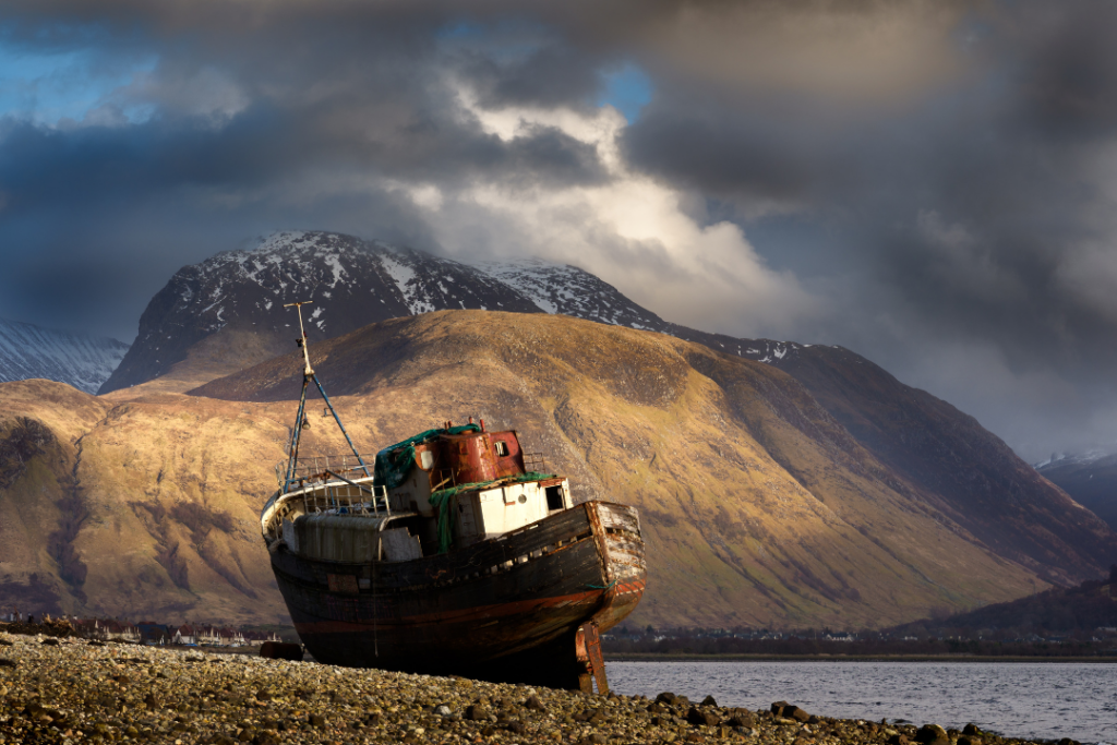 A view towards Ben Navis from Corpach near Fort William in the highlands of Scotland with a long abandoned boat